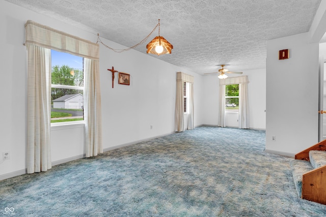 unfurnished living room with carpet flooring, a textured ceiling, and ceiling fan