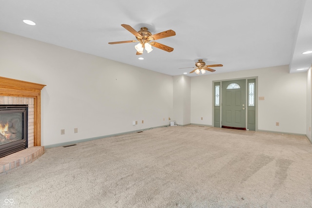 unfurnished living room with carpet flooring, ceiling fan, visible vents, and a fireplace