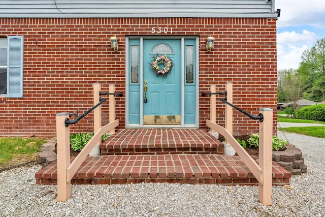 entrance to property featuring brick siding