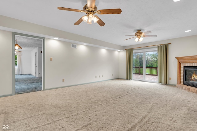 unfurnished living room with a ceiling fan, visible vents, a fireplace, carpet floors, and recessed lighting