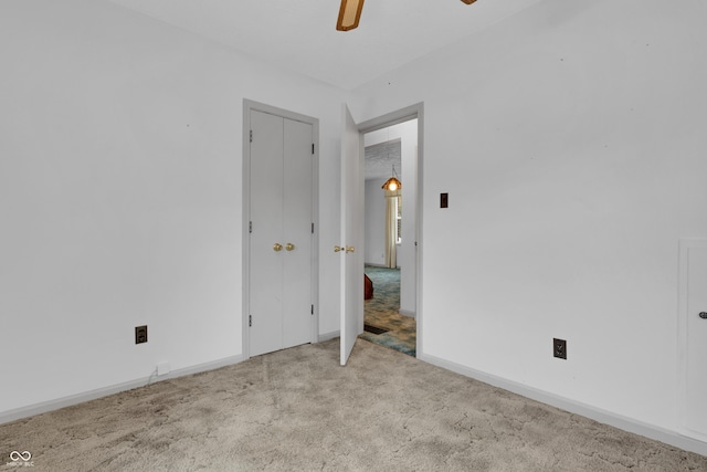 unfurnished bedroom featuring baseboards, ceiling fan, and carpet