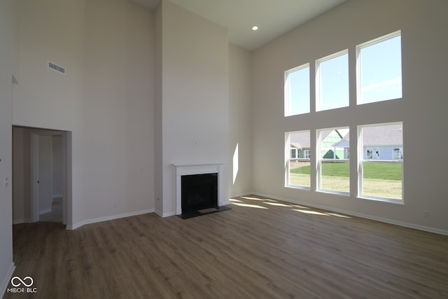 10543 Banyan Wood Ct, Indianapolis, IN 46239 - unfurnished living room with a high ceiling, wood finished floors, a fireplace with flush hearth, and baseboards