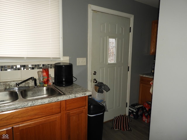 4920 E 34th St, Indianapolis, IN 46218 - kitchen featuring a sink, tasteful backsplash, brown cabinets, and wood finished floors