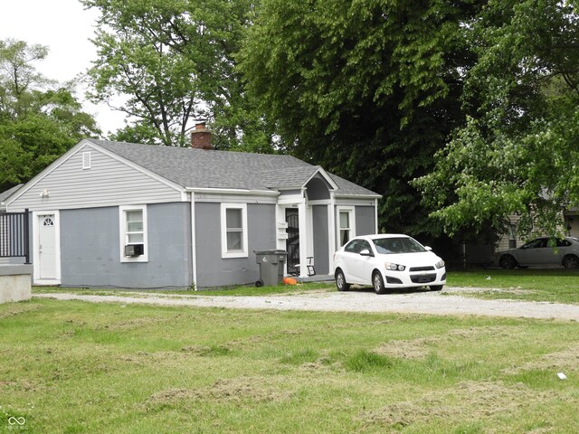 4920 E 34th St, Indianapolis, IN 46218 - single story home with a chimney, a shingled roof, a front lawn, and cooling unit