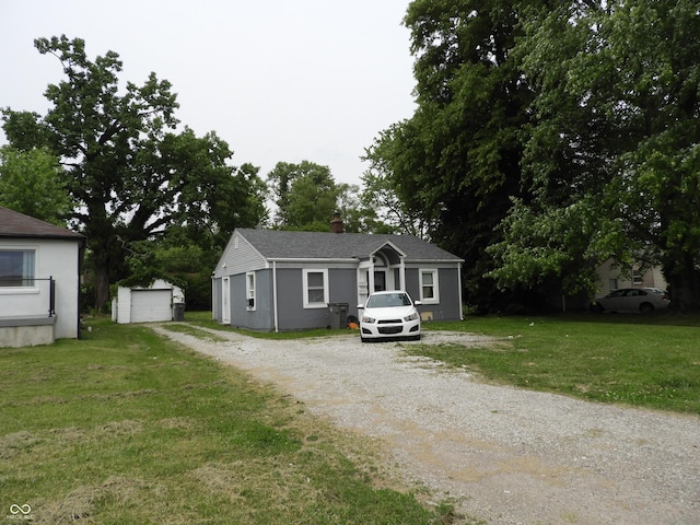 4920 E 34th St, Indianapolis, IN 46218 - view of front of home with driveway, an outbuilding, a front lawn, and a chimney