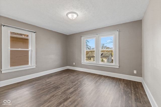 601 Wallace Ave, Indianapolis, IN 46201 - spare room with dark wood-style flooring, baseboards, and a textured ceiling