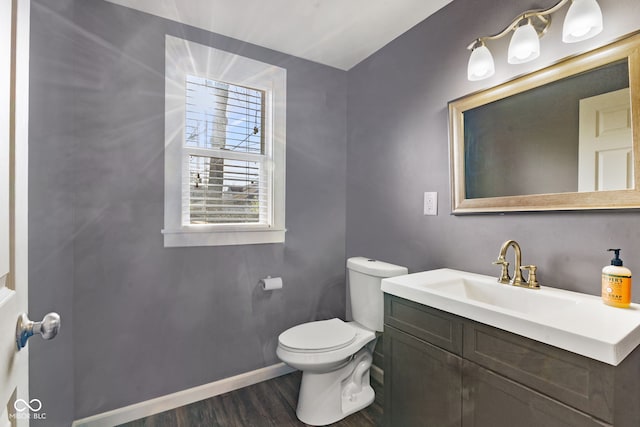 601 Wallace Ave, Indianapolis, IN 46201 - half bath featuring vanity, baseboards, toilet, and wood finished floors