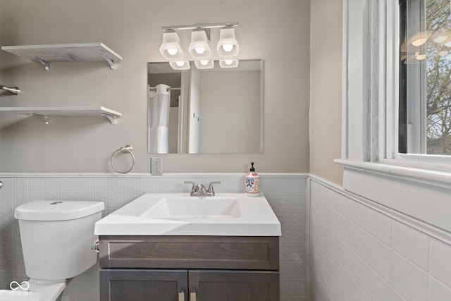 601 Wallace Ave, Indianapolis, IN 46201 - bathroom with toilet, vanity, tile walls, and a wainscoted wall