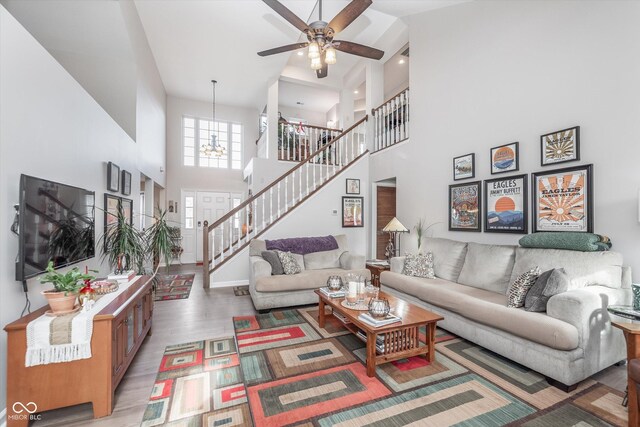 10518 Greenway Dr, Fishers, IN 46037 - living area featuring stairway, light wood-style floors, ceiling fan with notable chandelier, and a high ceiling