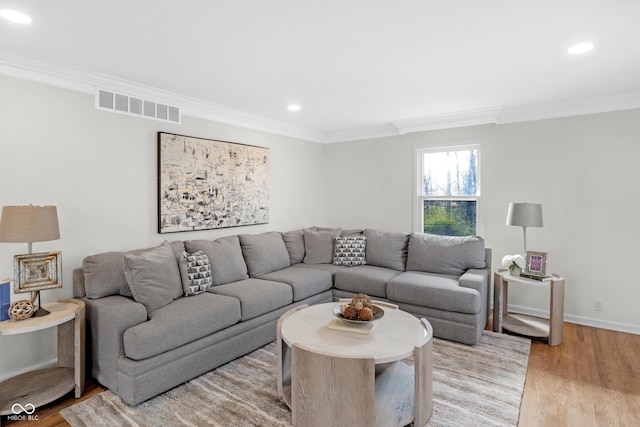 living room with wood finished floors, ornamental molding, visible vents, and recessed lighting