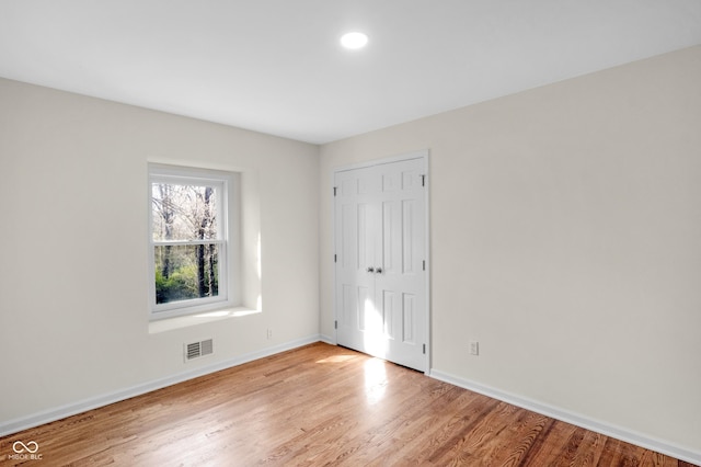 unfurnished bedroom with visible vents, baseboards, a closet, light wood finished floors, and recessed lighting