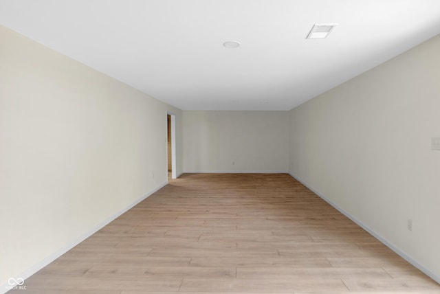empty room featuring visible vents, baseboards, and light wood-style floors