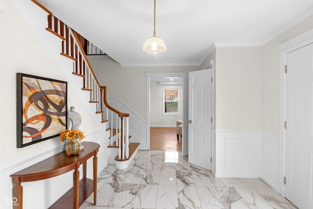 entrance foyer featuring stairs, a decorative wall, marble finish floor, and a wainscoted wall