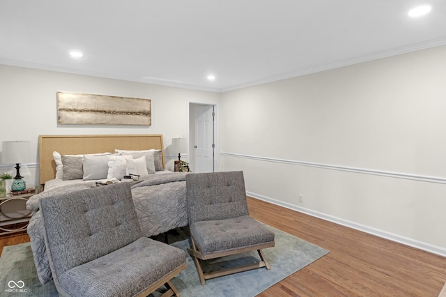bedroom with wood finished floors, baseboards, ornamental molding, and recessed lighting
