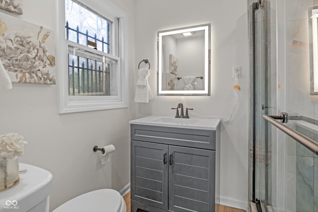 full bathroom featuring toilet, a stall shower, vanity, and baseboards