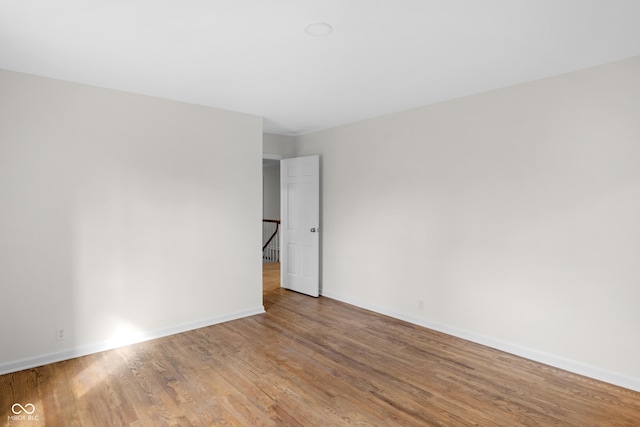 spare room featuring wood finished floors and baseboards
