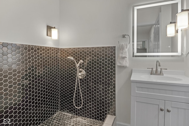 full bathroom with tiled shower and vanity