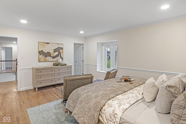 bedroom with wood finished floors, ornamental molding, and recessed lighting