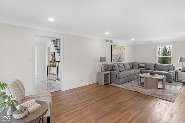 living area with visible vents, baseboards, crown molding, light wood finished floors, and recessed lighting