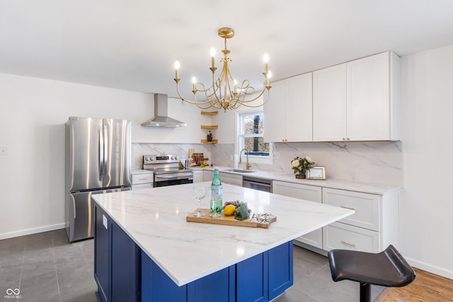 kitchen with tasteful backsplash, a chandelier, wall chimney range hood, stainless steel appliances, and a sink