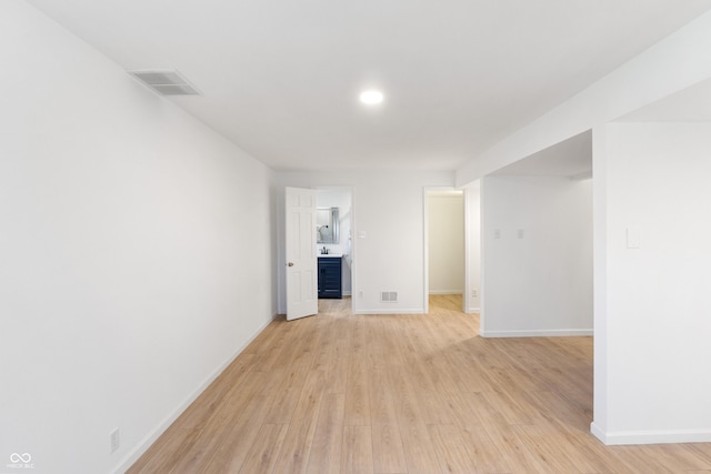 spare room with visible vents, baseboards, and light wood-type flooring