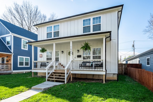 1603 E Market St, Indianapolis, IN 46201 - view of front of house with board and batten siding, a porch, fence, and a front lawn