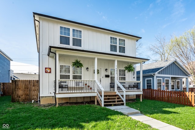 1603 E Market St, Indianapolis, IN 46201 - view of front facade featuring board and batten siding, covered porch, a front yard, and fence