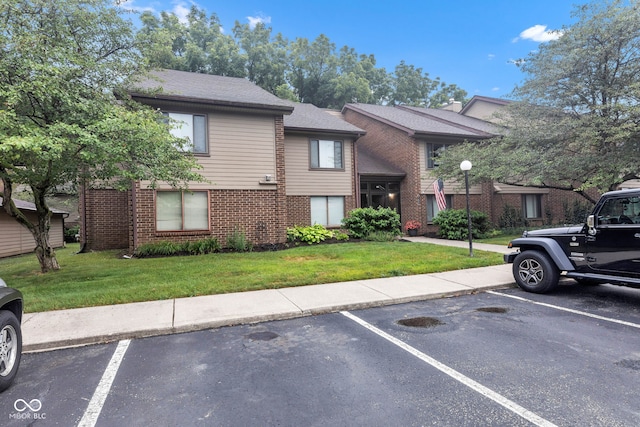 102 Knoll Ct Unit D, Noblesville, IN 46062 - view of front of property featuring brick siding, uncovered parking, and a front lawn
