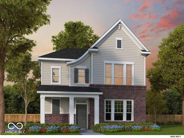 traditional home featuring roof with shingles, fence, and brick siding
