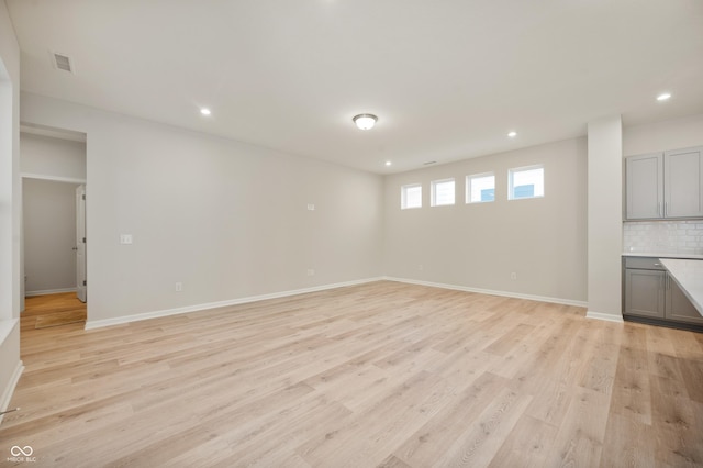 interior space featuring visible vents, baseboards, light wood finished floors, and recessed lighting