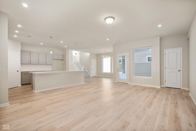 unfurnished living room featuring a sink, light wood-style flooring, and recessed lighting