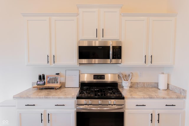 kitchen with white cabinets, light stone countertops, and stainless steel appliances