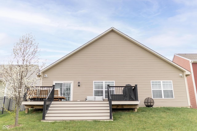 rear view of property with a wooden deck and a yard