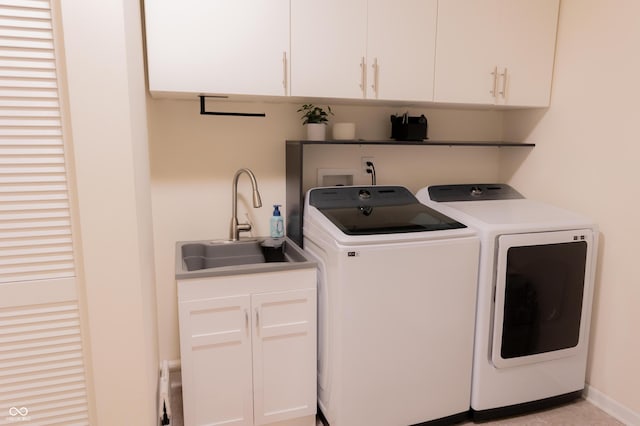 laundry room featuring washer and clothes dryer, a sink, and cabinet space