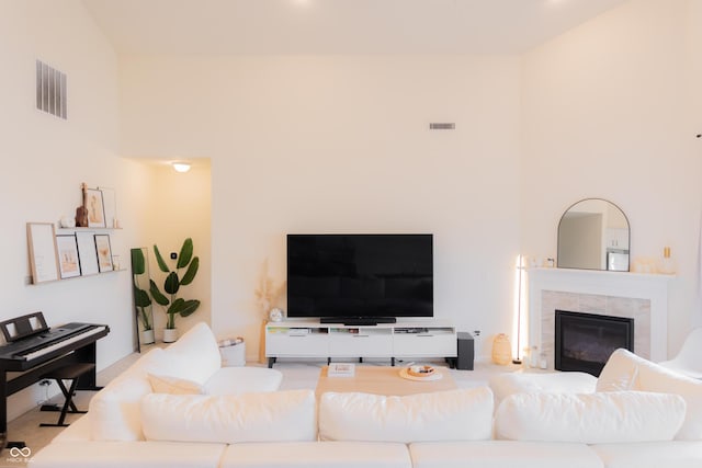 living area with a towering ceiling, a fireplace, and visible vents