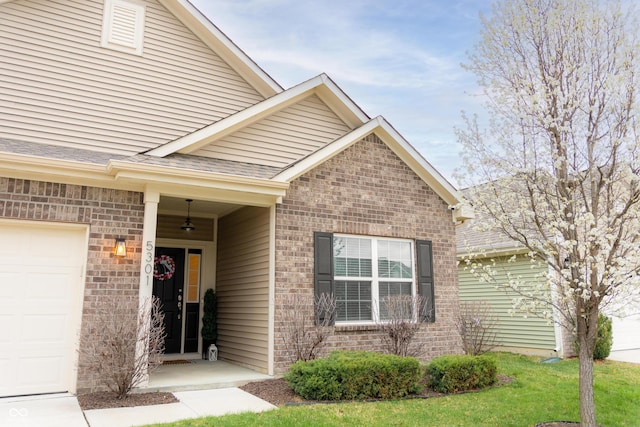 entrance to property with brick siding, a garage, and a shingled roof