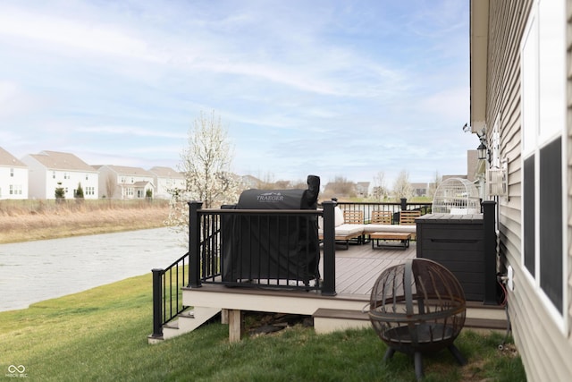 deck with a yard, a water view, and a residential view