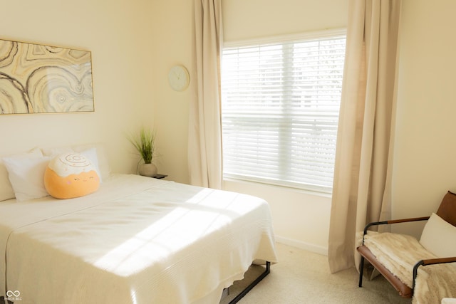 bedroom with carpet flooring, baseboards, and multiple windows