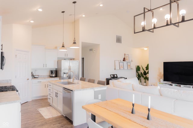 kitchen with visible vents, open floor plan, high vaulted ceiling, a sink, and appliances with stainless steel finishes