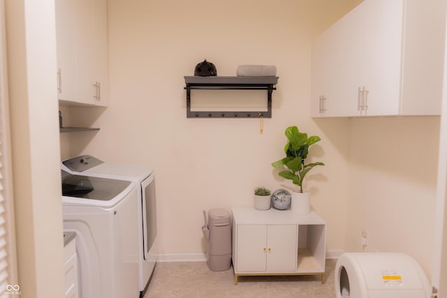 clothes washing area with baseboards, cabinet space, and washing machine and dryer