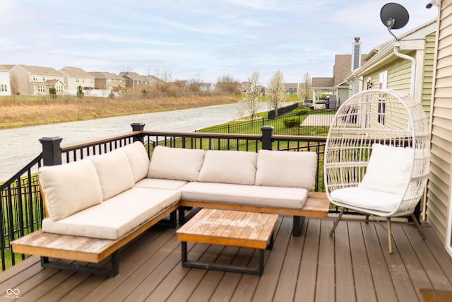 wooden deck with a water view, outdoor lounge area, fence, and a residential view