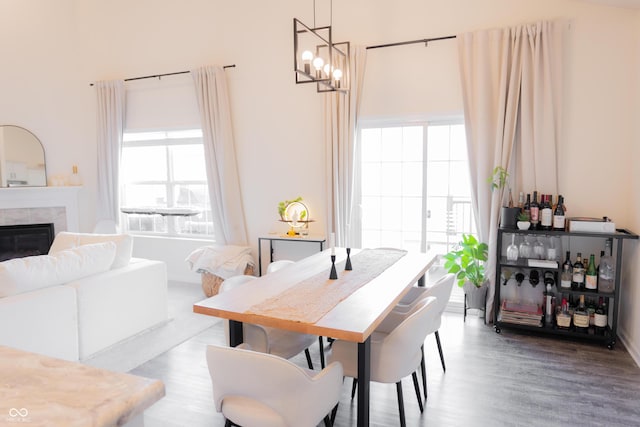 dining area with wood finished floors, a chandelier, and a fireplace