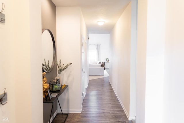 hallway with baseboards and dark wood-style floors