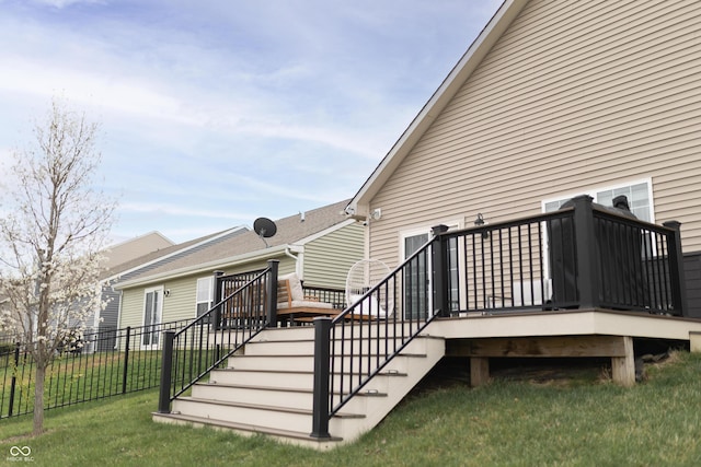 deck featuring a yard, fence, and stairs