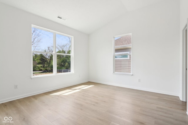 unfurnished bedroom featuring vaulted ceiling, light wood-style flooring, and baseboards