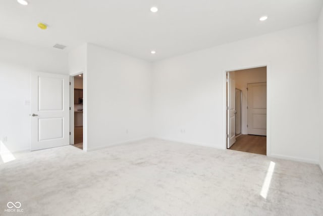 spare room featuring carpet, recessed lighting, and baseboards