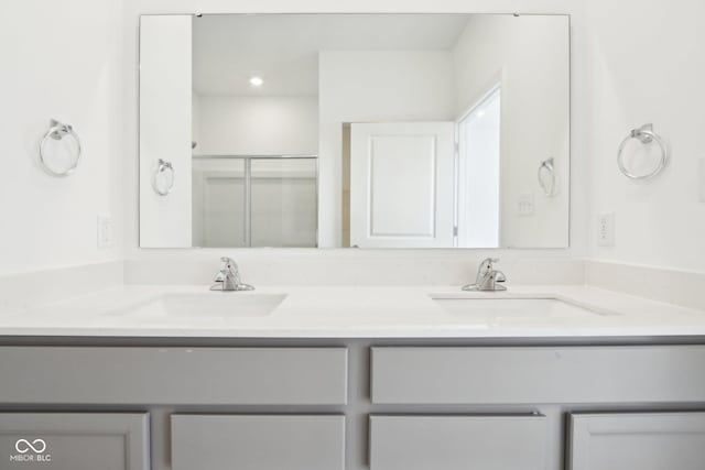 bathroom with double vanity and a shower with shower door
