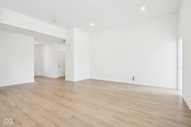 empty room with light wood-style flooring, recessed lighting, and baseboards