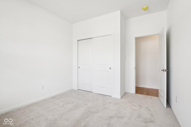 unfurnished bedroom with carpet flooring, a closet, and baseboards