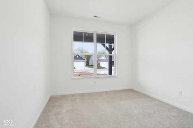 carpeted spare room featuring baseboards
